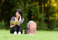 Portrait of happy charming Thai woman reading a book