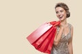 Portrait of happy charming woman holding red shopping bags.