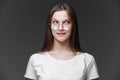 Portrait of happy charming young woman with long hair in white t shirt and glasses smiling looking to the side, thinking and Royalty Free Stock Photo