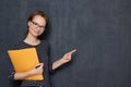 Portrait of happy cheerful girl holding folder, pointing at copy space Royalty Free Stock Photo