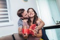 Happy cheerful husband giving present box to his pregnant wife Royalty Free Stock Photo