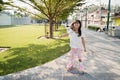 Portrait of a happy and cheerful little girl playing roller skating in the park