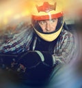 Portrait of male racer in helmet driving kart on track