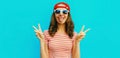 Portrait happy cheerful smiling young woman showing her tongue wearing red baseball cap on blue background Royalty Free Stock Photo