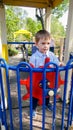 Portrait of happy cheerful toddler boy pretending to be a captain of ship on the children playground at park and