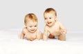 Portrait of happy cheerful two twin babies crawling and playing on the bed on white background Royalty Free Stock Photo