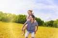 Portrait of Happy and Cheerful Young Caucasian Couple Piggybacking Outdoors.Summer Vacations and Youth Lifestyle Concept. Against Royalty Free Stock Photo