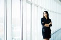 Attractive smiling young business woman. Portrait of happy cheerful young lady with crossed arms on business center window backgro Royalty Free Stock Photo