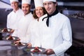 Portrait of happy chefs presenting their dessert plates Royalty Free Stock Photo