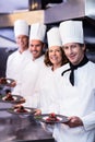 Portrait of happy chefs presenting their dessert plates Royalty Free Stock Photo