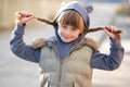 Portrait of happy child girl with hair braids in warm clothes in autumn outdoors Royalty Free Stock Photo