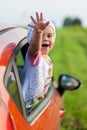 Portrait of happy child girl sticking their head out the car win Royalty Free Stock Photo