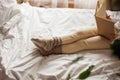 Portrait of happy child. Little beautiful curly girl is reading book in her bed. Cozy house Royalty Free Stock Photo