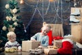 Portrait of happy child looking at decorative toy ball by Christmas tree. Happy small kids in santa hat with present Royalty Free Stock Photo