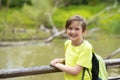 smiling adorable boy with a backpack in the park near the river. Royalty Free Stock Photo