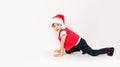 Portrait of happy child standing on the start in Santa Claus hat isolated on white background. 5 year European boy starting run a