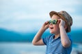 Portrait of happy child in sunglasses on the beach. Summer vacation concept. Smiling kid boy in hat and glasses near sea Royalty Free Stock Photo