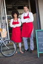 Portrait of happy colleagues in red apron posing Royalty Free Stock Photo