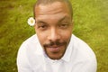 Portrait of happy confident young African-American businessman in formal wear sitting at city park with flower.Blurred Royalty Free Stock Photo