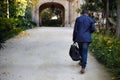 Portrait of Happy confident young African-American businessman in formal wear walking at city park with travel bag Royalty Free Stock Photo