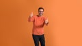 Portrait of happy confident young businessman showing two thumbs up on isolated orange background Royalty Free Stock Photo