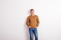 Portrait of a happy young man standing in a studio, hands in pockets. Royalty Free Stock Photo