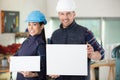 portrait happy construction workers holding blank billboards Royalty Free Stock Photo