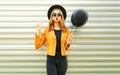 Happy cool girl blowing red lips sends air kiss holding black air balloon Royalty Free Stock Photo