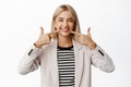 Portrait of happy corporate woman pointing fingers at teeth and smiling, concept of dental clinic, vinirs and perfect Royalty Free Stock Photo