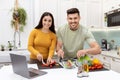 Portrait of happy couple enjoying time together, cooking dinner Royalty Free Stock Photo