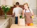 Portrait of happy couple with grocery paper bag with vegetables