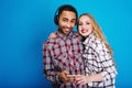 Portrait happy couple having fun together on blue background. Stylish outlook, enjoying free time, happiness, listening Royalty Free Stock Photo