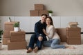 Portrait happy couple hugging, enjoying moving day, sitting on floor Royalty Free Stock Photo