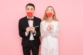 Portrait of happy couple in love holding paper hearts, on pink background, lovers day concept