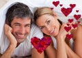 Portrait of happy couple lying on bed at home