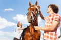 Portrait of happy couple with purebred bay horse Royalty Free Stock Photo