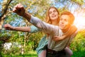 Portrait of happy couple raising their hands in open air