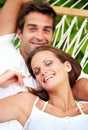 Portrait, happy couple and relax on hammock in nature, love and vacation in summer on tropical island. Young man, woman Royalty Free Stock Photo