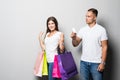 Portrait of a happy couple with a shopping bag with a card and looking at camera on white background Royalty Free Stock Photo