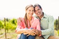 Portrait of happy couple sitting in vineyard