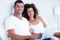 Portrait of happy couple using laptop on bed Royalty Free Stock Photo