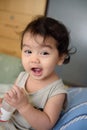 Portrait of happy curly hair Asian baby girl, she have big smile and look at camera, baby expression concept