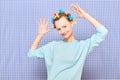 Portrait of happy cute girl with bright colorful hair curlers on head Royalty Free Stock Photo