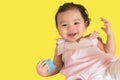 Portrait of happy cute little Asian baby girl wear pink dress holding a toy,  smile and looking camera, baby expression concept Royalty Free Stock Photo