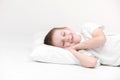 Portrait of a happy cute little boy waking up in the morning and lying on a white pillow isolated on a white background. fresh and Royalty Free Stock Photo