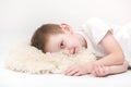 Portrait of a happy cute little boy waking up in the morning and lying on a white pillow isolated on a white background. fresh and Royalty Free Stock Photo