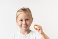 Portrait of happy cute little caucasian girl holding supplement capsule of Omega 3 on the white background. Multivitamin pill