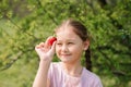 Portrait of Happy cute little girl is eating strawberries at summer day. Soft focused Royalty Free Stock Photo