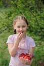 Portrait of Happy cute little girl is eating strawberries at summer day. Soft focused Royalty Free Stock Photo
