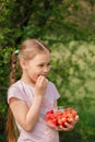 Portrait of Happy cute little girl is eating strawberries at summer day. Soft focused. Vertical Royalty Free Stock Photo